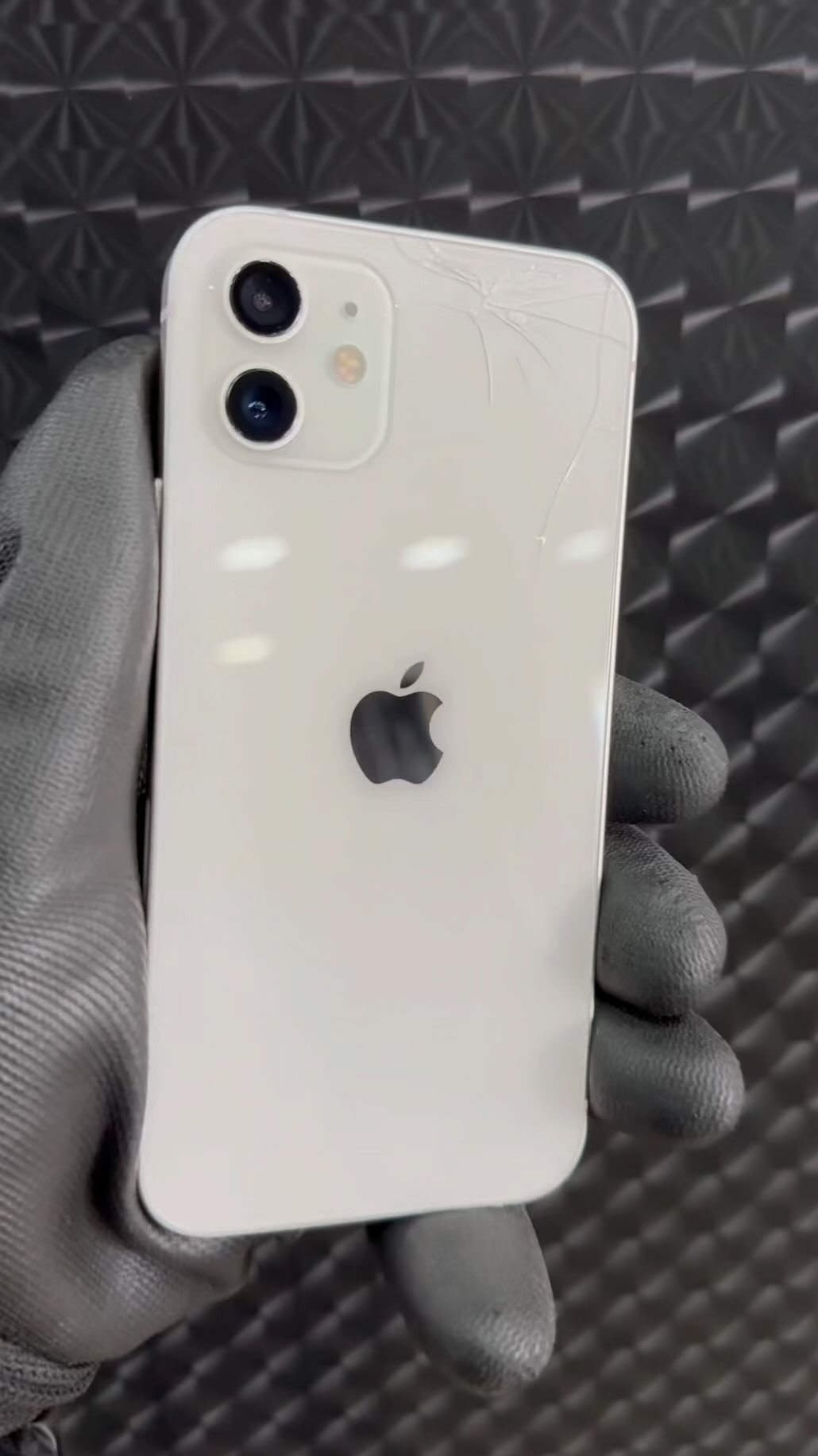 iPhone com o vidro traseiro quebrado em avaliação pela equipe da Iron Case